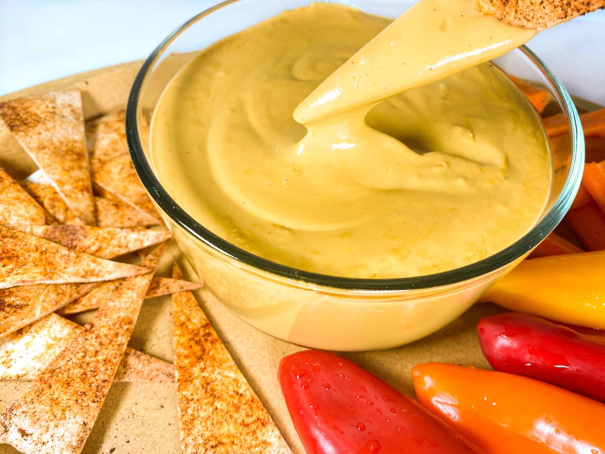Dipping chip in cheese sauce.