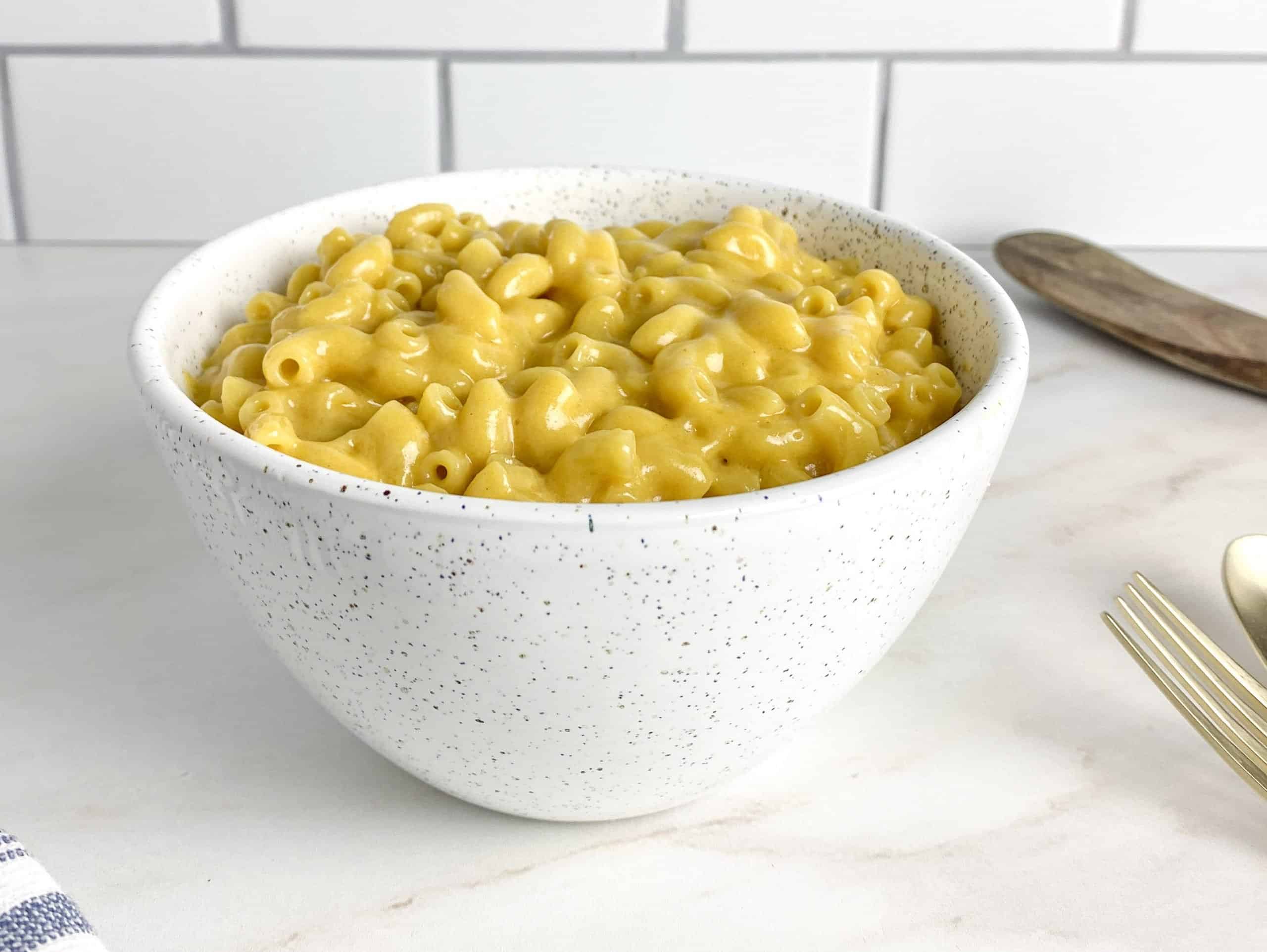Dairy-free Mac and cheese in a white speckled bowl.