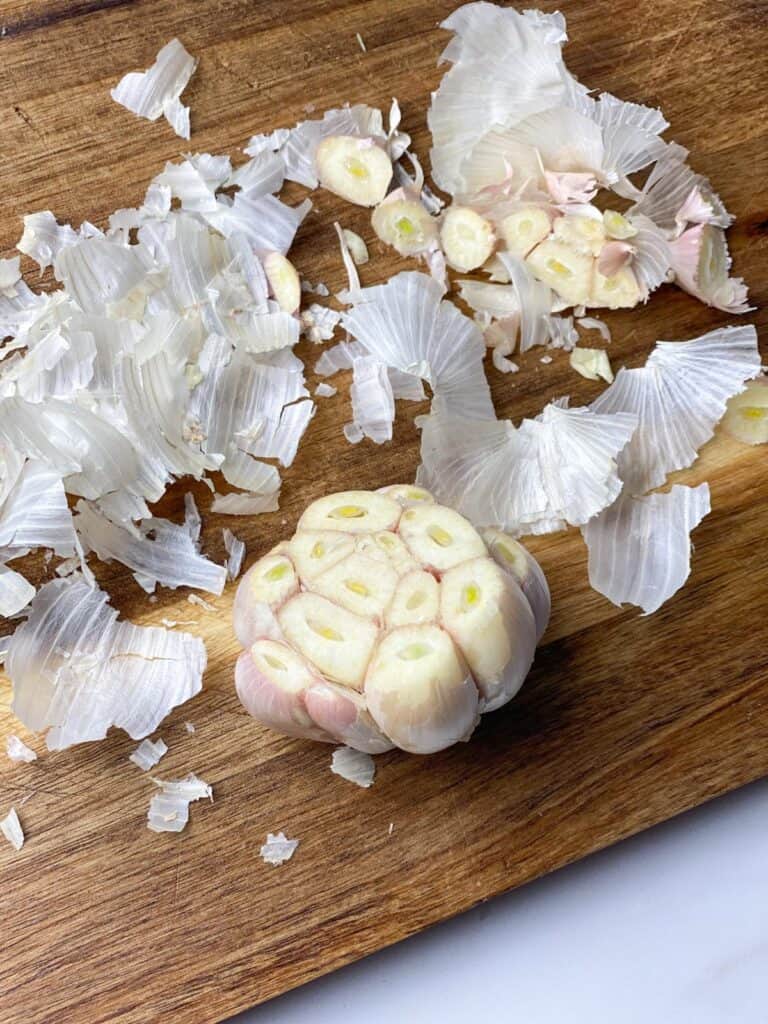 Raw garlic bulb with the top sliced off and most of the skins removed.