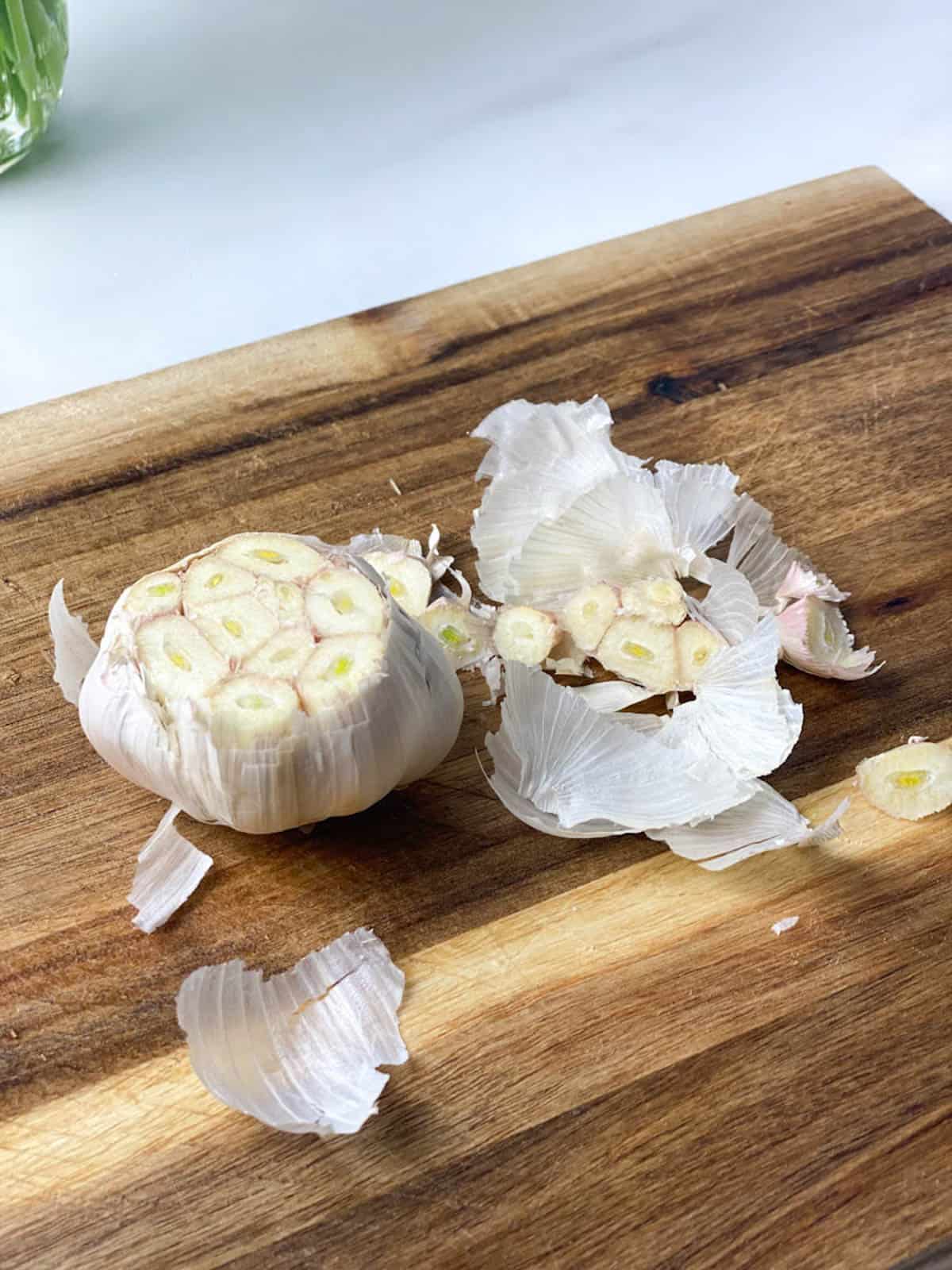 Bulb of garlic with the top cut off and most of the skins still in tact.
