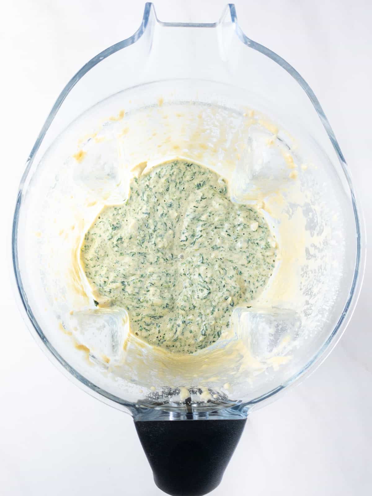 Dairy-free spinach artichoke dip mixed in a blender.