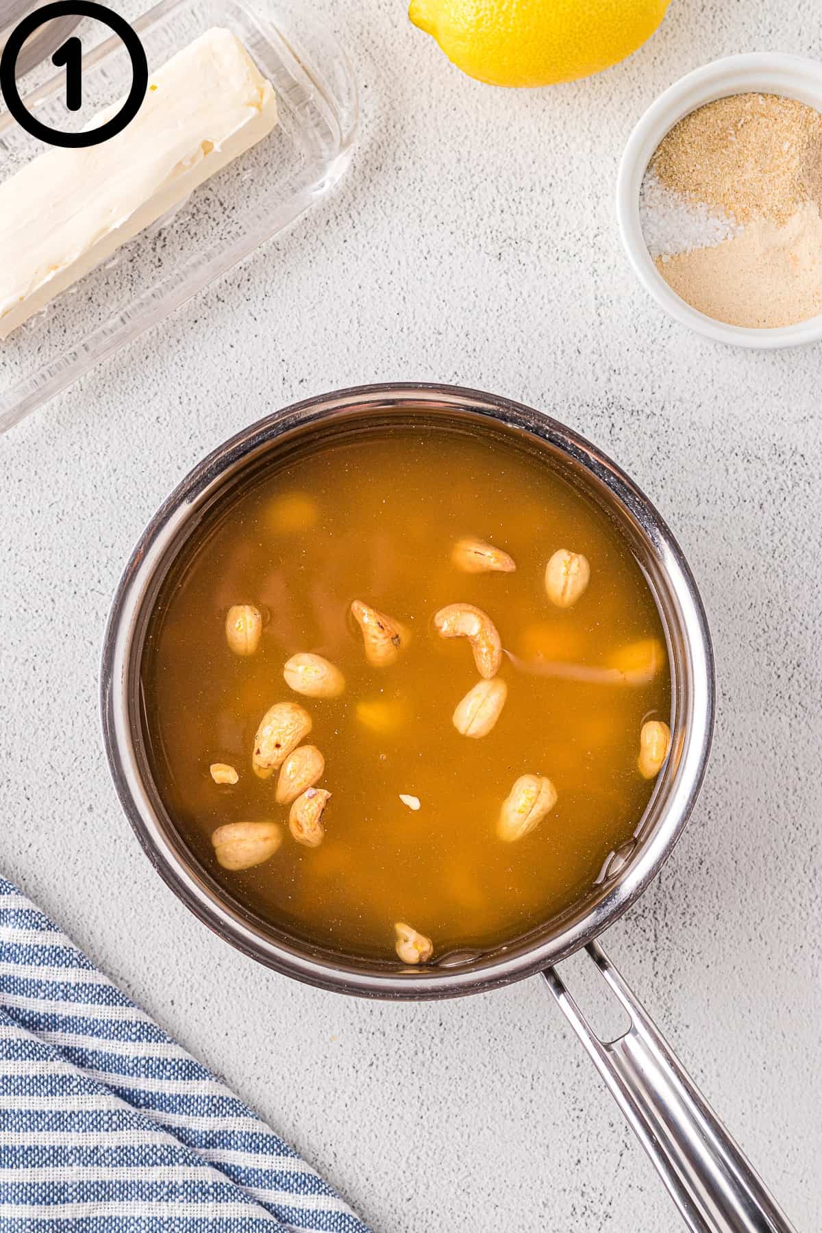 Cashews with chicken broth in a pot.
