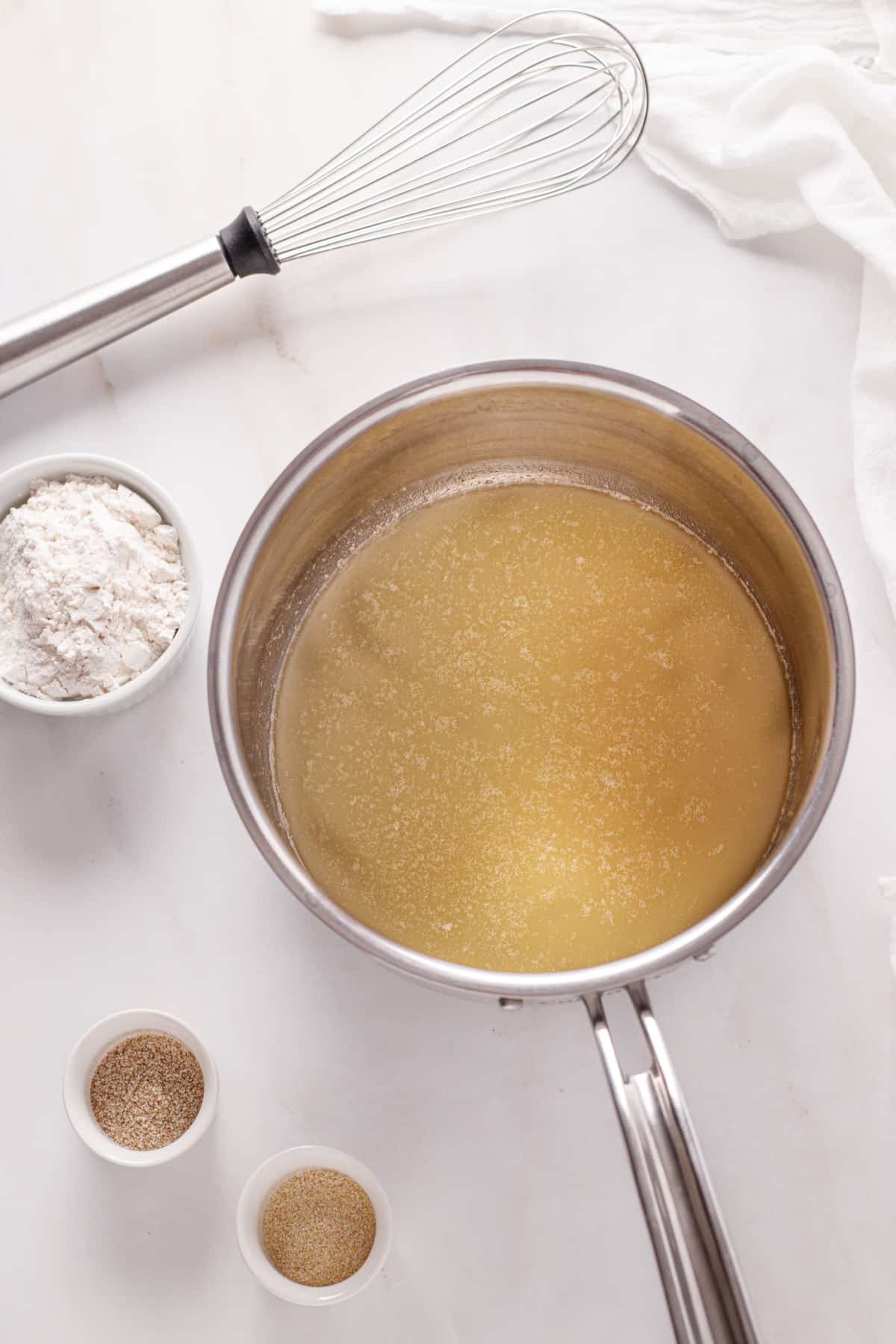 Melted butter in a stainless steel pot.