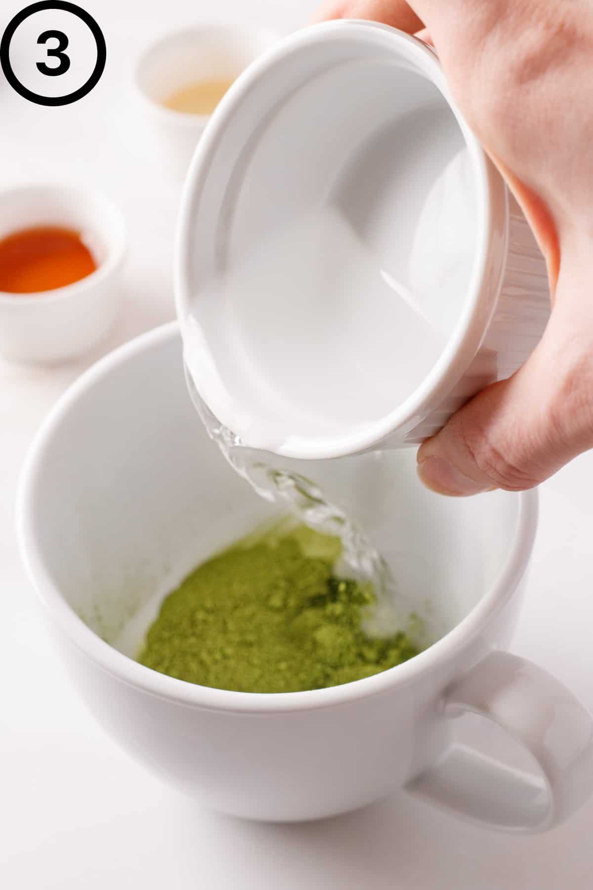 Pouring hot water into the mug of matcha.