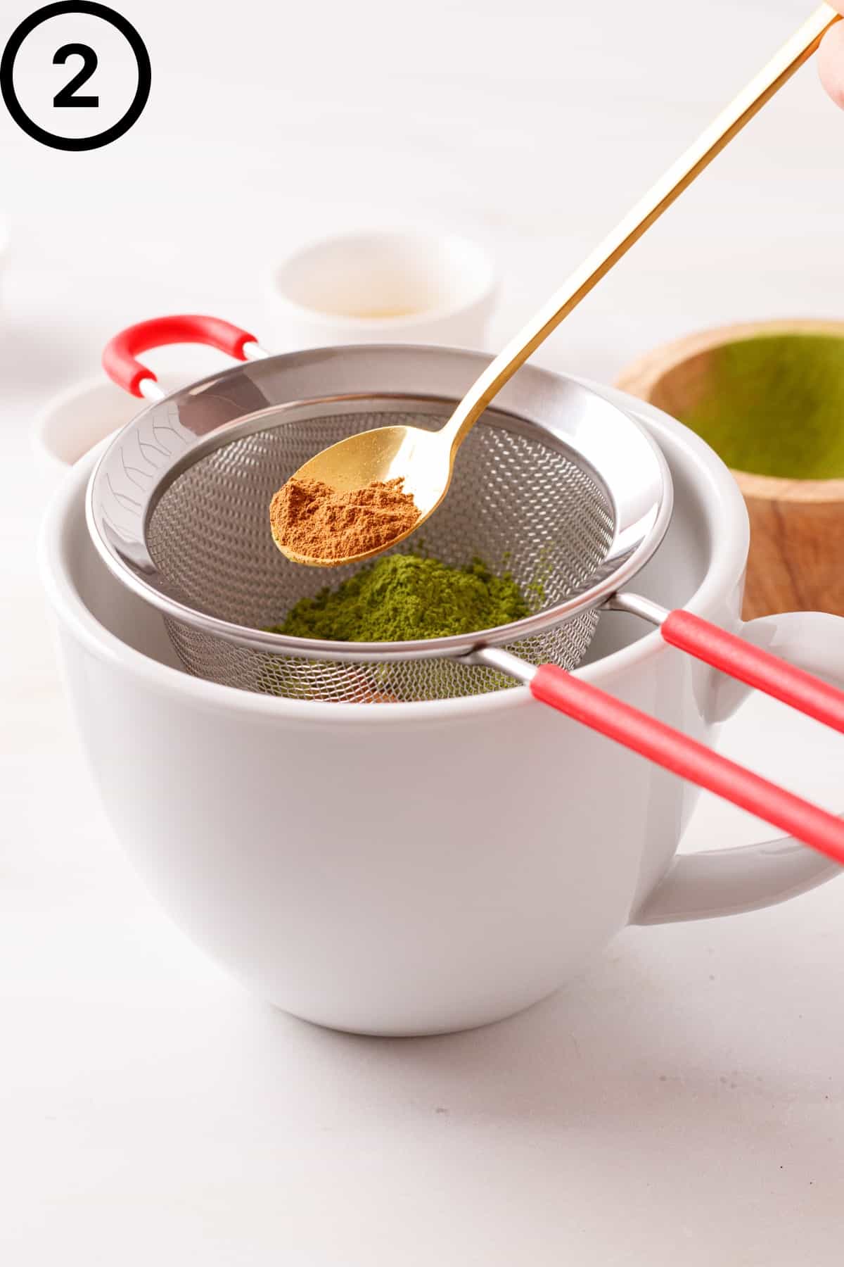 Sifting cinnamon in a mug.