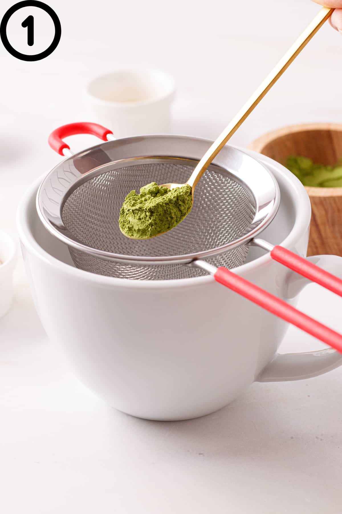 Sifting matcha into a mug.