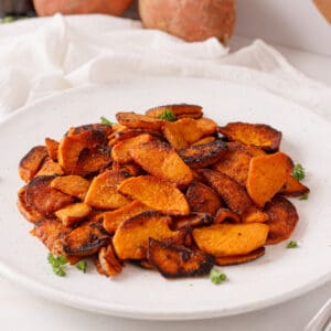 Sautéed sweet potatoes on a white plate.