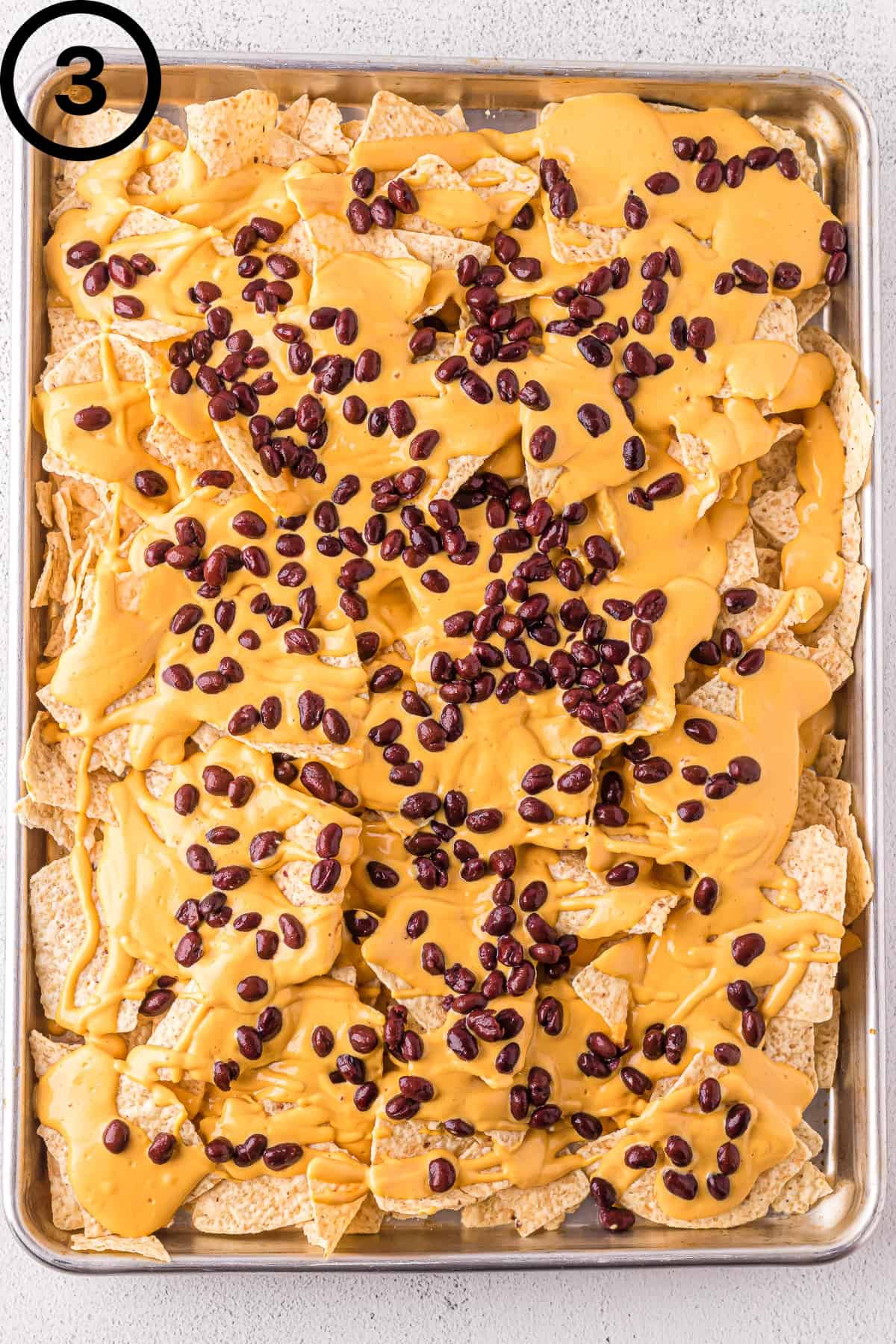 Dairy-free nachos with vegan cheese sauce and black beans.