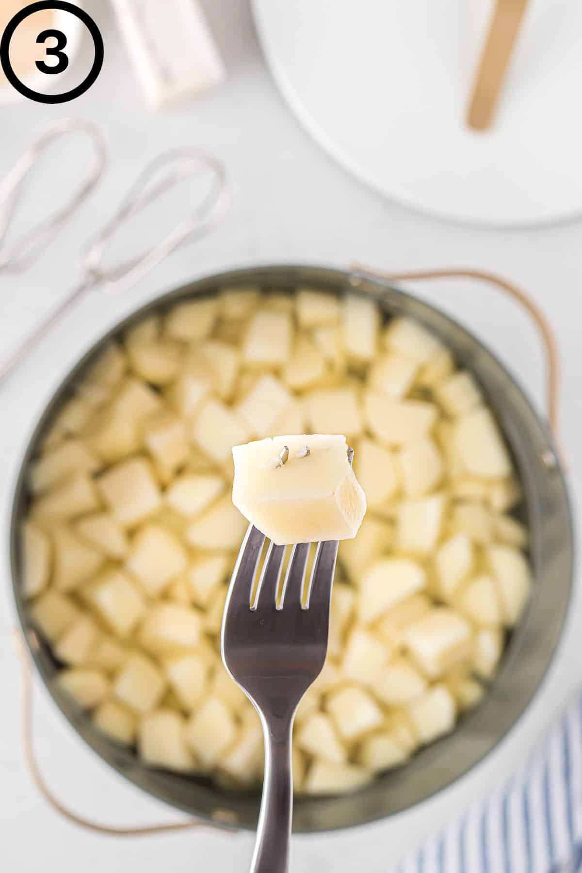 A fork poking through a tender potato.