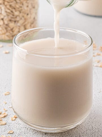 Pouring oat milk into a glass.