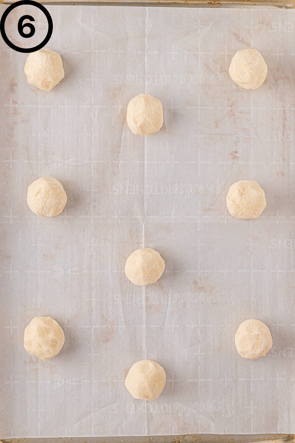 Sugar cookie dough balls on a baking sheet.
