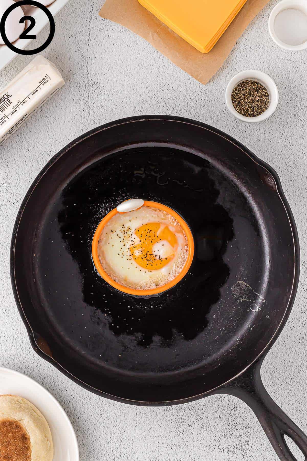 An egg cooking in a silicone egg ring.