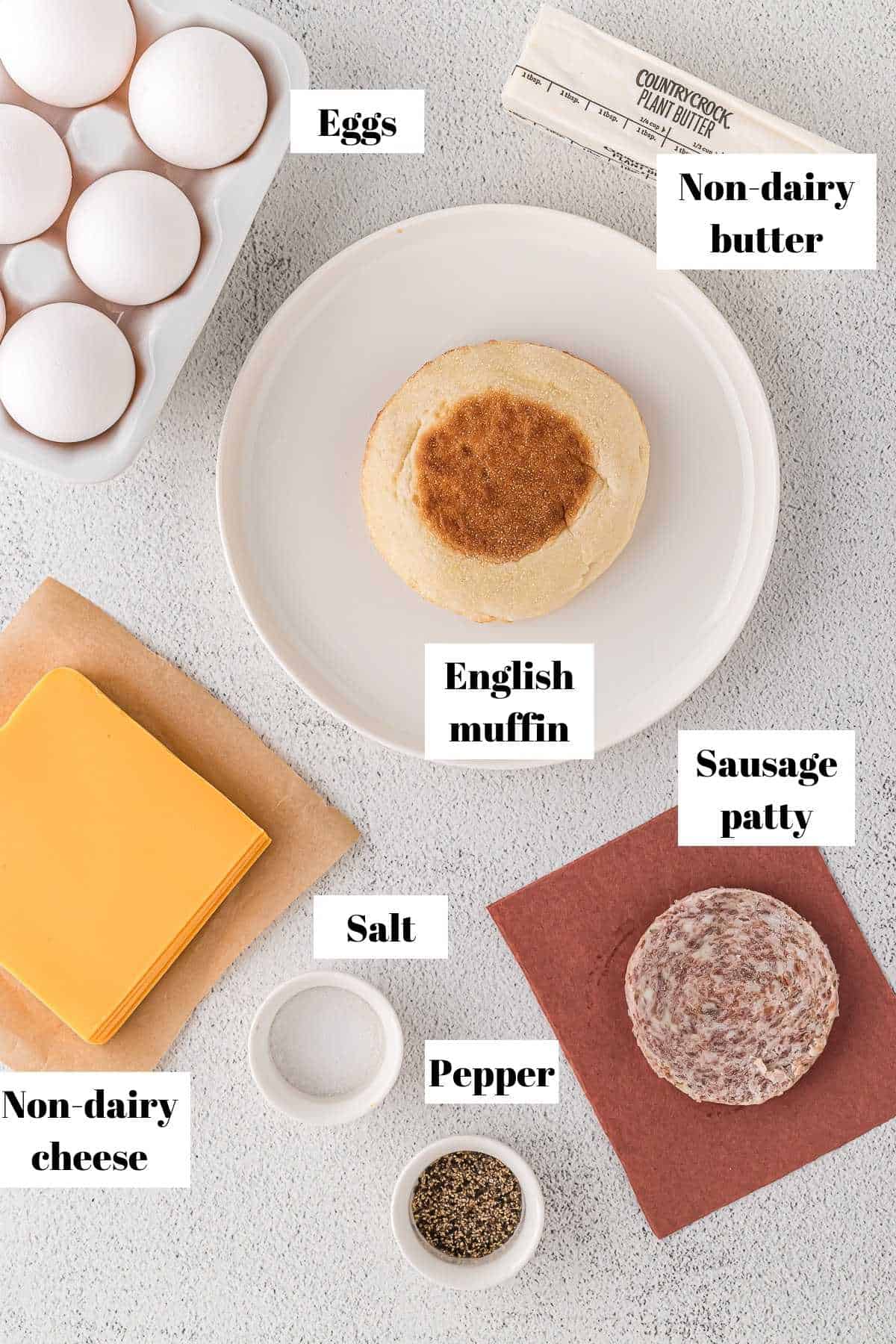 Ingredients to make a sausage breakfast sandwich. Text on image for labeling ingredients.
