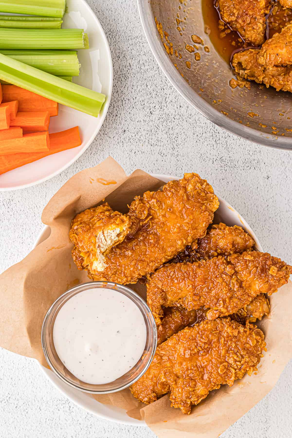 Hot honey chicken tenders in a bowl with parchment paper.