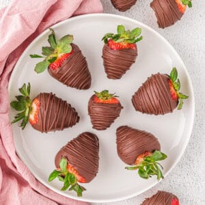 Vegan chocolate covered strawberries on a white plate.