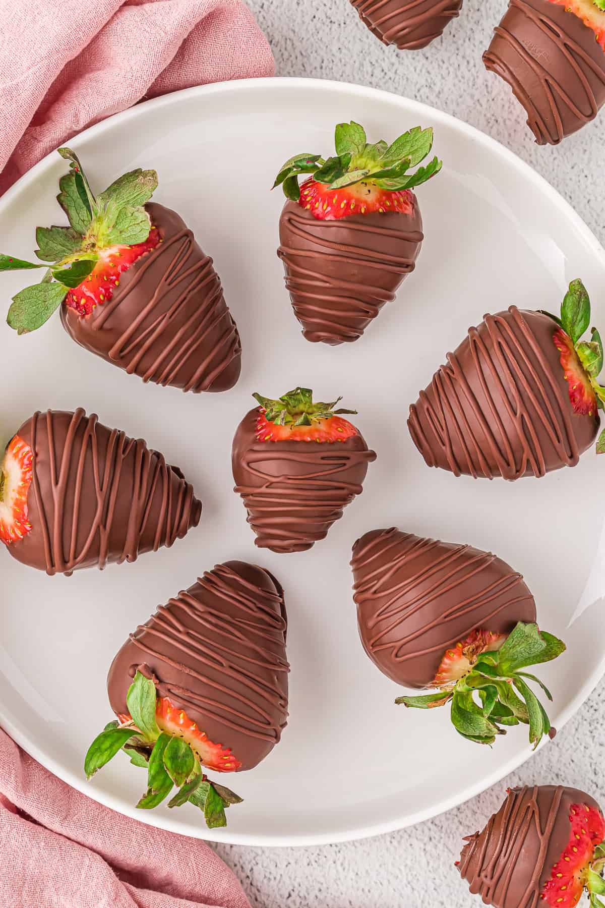 Vegan chocolate covered strawberries on a white plate.